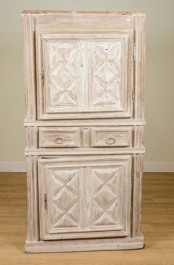 AN 18TH CENTURY FRENCH LATER LIMED OAK TWO DOOR SIDE CABINET WITH RAISED GEOMETRIC PANELS