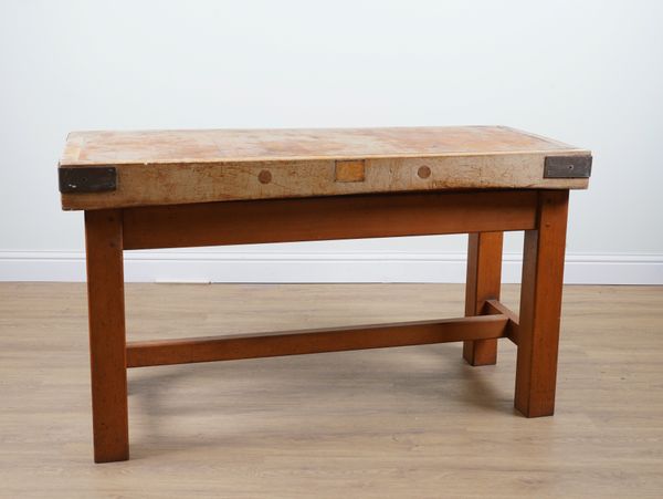 A LARGE RECTANGULAR METAL BOUND BEECH BUTCHER’S BLOCK ON BLOCK SUPPORTS