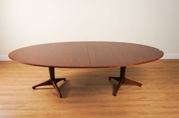 ANDREW MILNE; A MID-20TH CENTURY ROSEWOOD VENEERED OVAL EXTENDING DINING TABLE