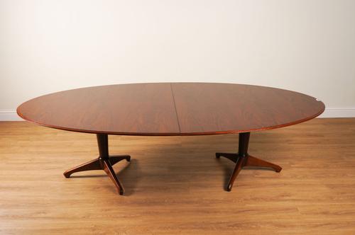 ANDREW MILNE; A MID-20TH CENTURY ROSEWOOD VENEERED OVAL EXTENDING DINING TABLE