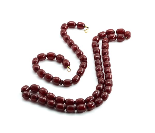 TWO SINGLE ROW NECKLACES OF CHERRY COLOURED SIMULATED AMBER BEADS (2)