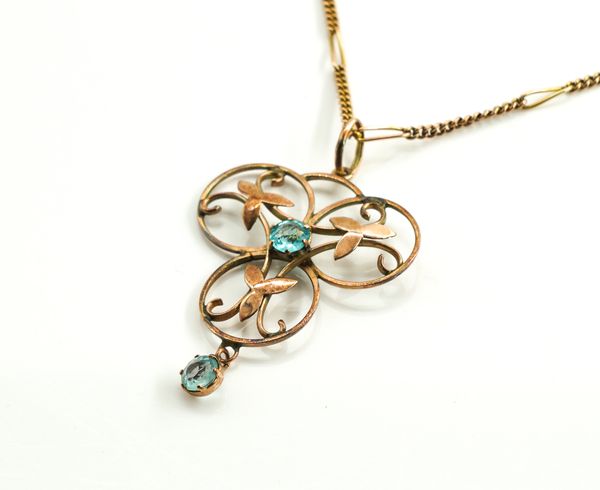 A GOLD AND PALE BLUE GEM SET PENDANT WITH A GOLD NECKCHAIN