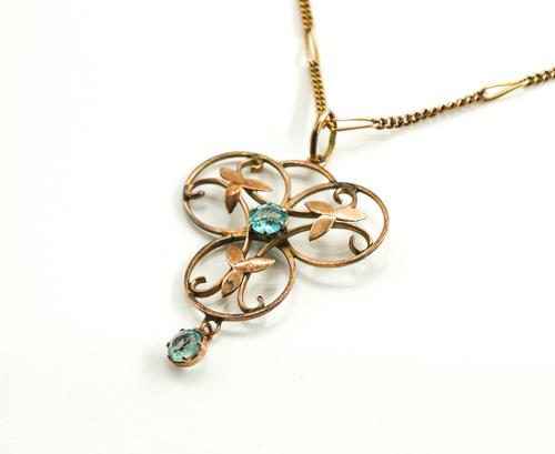 A GOLD AND PALE BLUE GEM SET PENDANT WITH A GOLD NECKCHAIN
