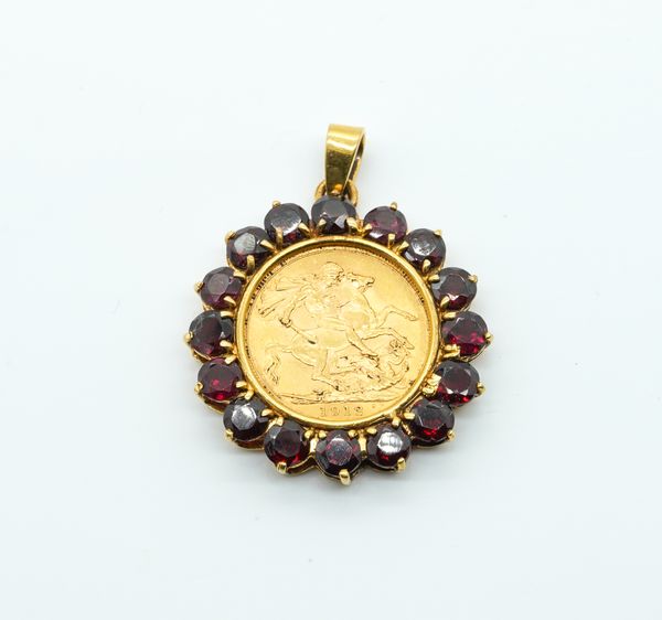 A GEORGE V SOVEREIGN IN A 9CT GOLD AND GARNET SET PENDANT MOUNT