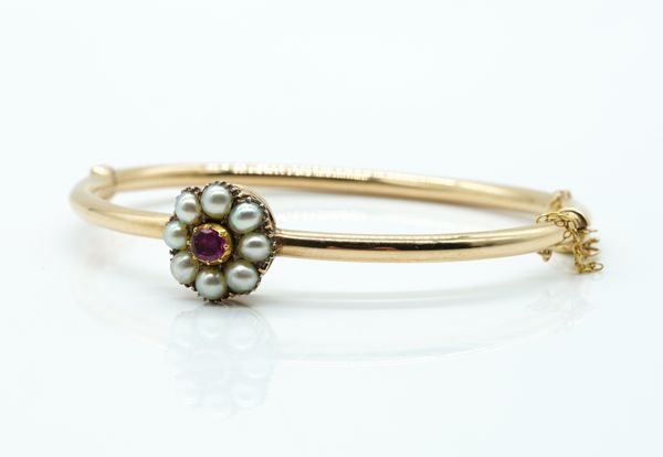 A GOLD, RUBY AND HALF PEARL OVAL CLUSTER BANGLE