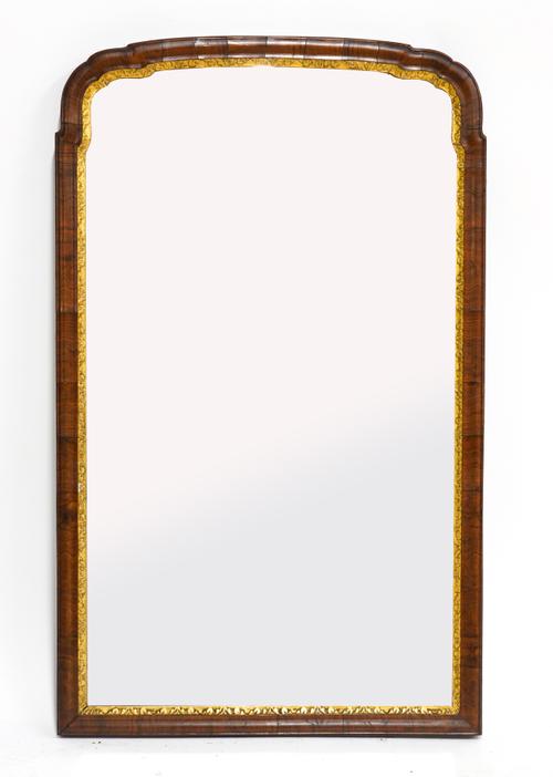 A QUEEN ANNE STYLE PARCEL GILT FIGURED WALNUT SHAPED ARCH TOP MIRROR