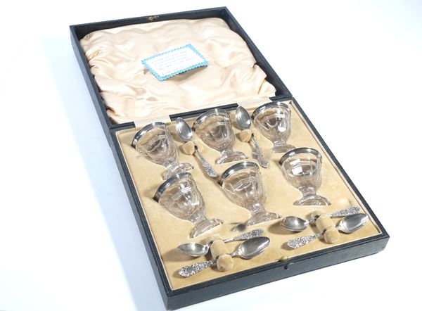 A SILVER MOUNTED AND CUT GLASS SIX EGG CUP SET WITH SIX SPOONS