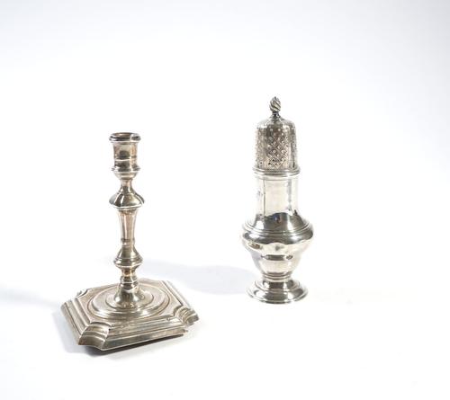 A GEORGE III SILVER SUGAR CASTER AND A VICTORIAN SILVER TAPER STICK (2)