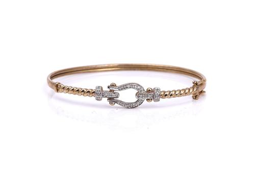 A 9CT GOLD AND DIAMOND SET OVAL BANGLE