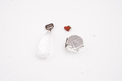 TWO ROCK CRYSTAL PENDANT DROPS AND A CARVED CORAL BULL'S HEAD FITTING (3)