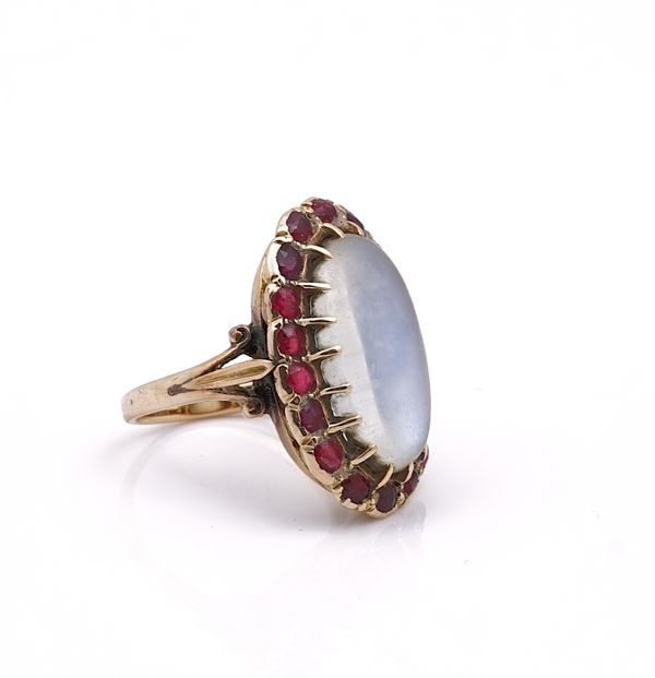 A GOLD, MOONSTONE AND RED GEM SET RING
