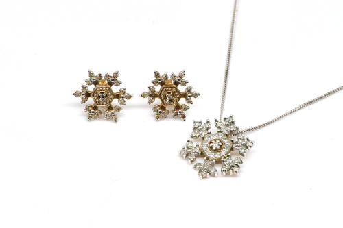 A 9CT GOLD AND DIAMOND SNOWFLAKE PENDANT WITH A 9CT WHITE GOLD NECKCHAIN AND A PAIR OF MATCHING EARSTUDS