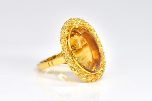 A 9CT GOLD AND OVAL CUT CITRINE SINGLE STONE RING