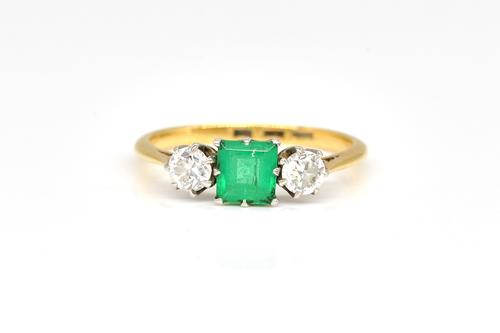 A GOLD, EMERALD AND DIAMOND THREE STONE RING
