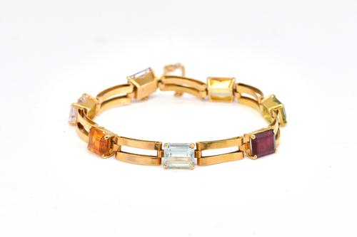 A GOLD AND VARICOLOURED GEMSTONE SET BRACELET
