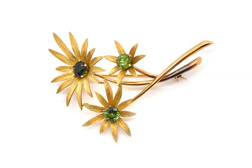 A GOLD AND GREEN GEMSTONE SET BROOCH