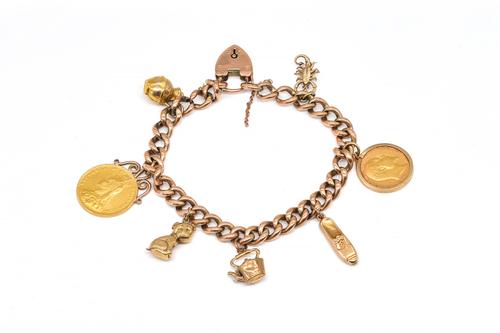 A GOLD CURB LINK CHARM BRACELET