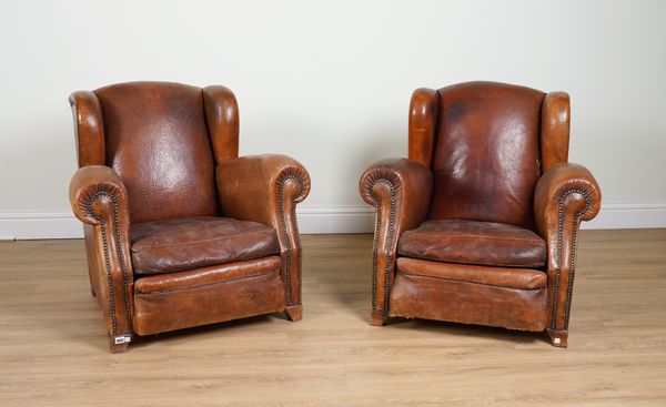 A PAIR OF EARLY 20TH CENTURY BRASS STUDDED TAN LEATHER UPHOLSTERED WINGBACK EASY ARMCHAIRS (2)