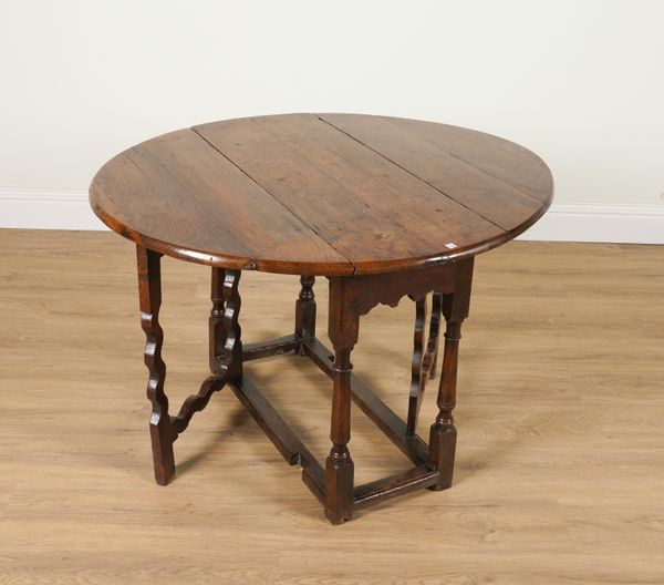 A 17TH CENTURY OAK DROP-LEAF TABLE ON SHAPED SILHOUETTE SUPPORTS