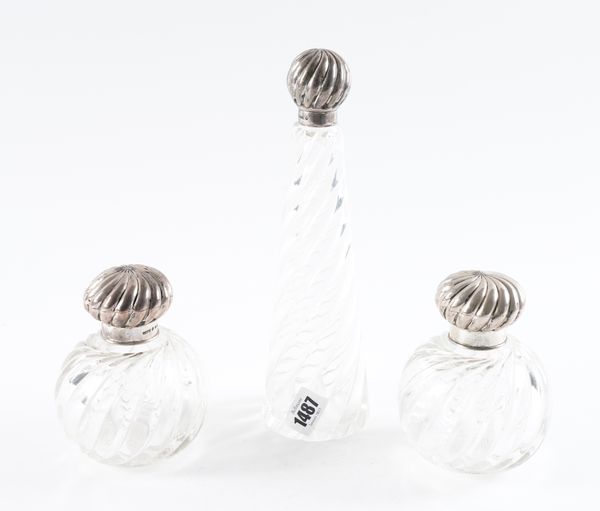 A SILVER TOPPED SCENT BOTTLE TOGETHER WITH A PAIR OF SILVER TOPPED SCENT BOTTLES (3)