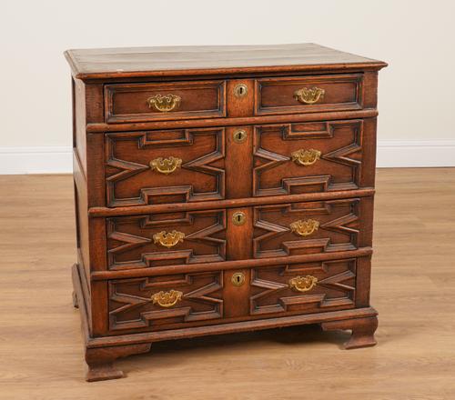A CHARLES II AND LATER OAK GEOMETRIC MOULDED FOUR DRAWER CHEST