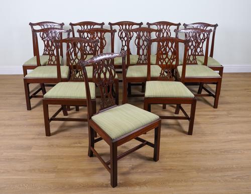 A SET OF TWELVE GEORGE III STYLE MAHOGANY FRAMED PIERCED SPLAT BACK DINING CHAIRS (12)