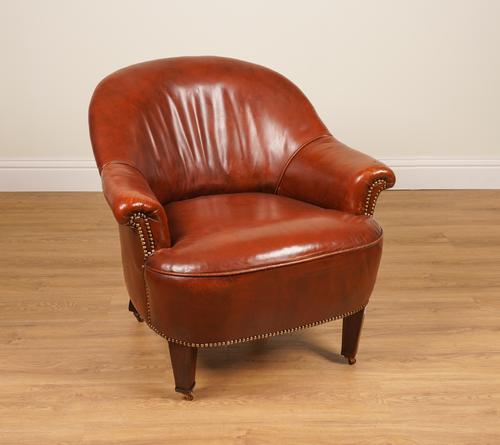 A STUDDED TAN LEATHER UPHOLSTERED TUB BACK EASY ARMCHAIR