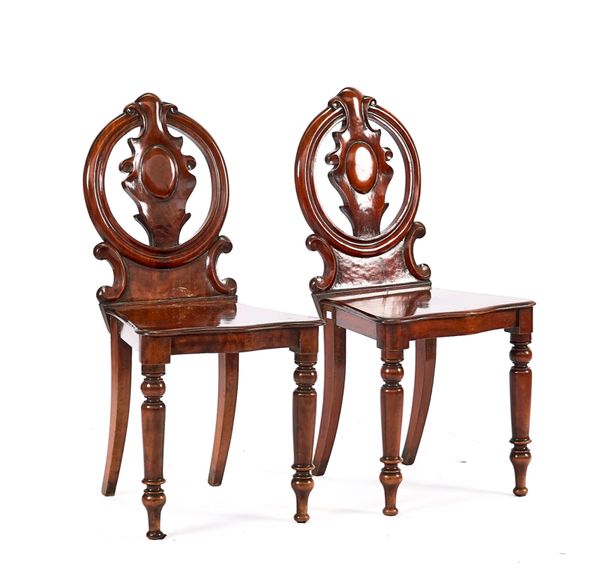 A PAIR OF VICTORIAN MAHOGANY PIERCED CIRCULAR BACK HALL CHAIRS