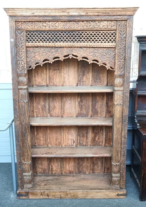 AN EXTENSIVELY CARVED INDIAN HARDWOOD OPEN BOOKCASE