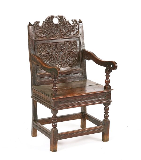 A CHARLES II JOINED OAK PANEL-BACK OPEN ARMCHAIR