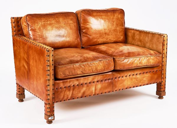 A MID-20TH CENTURY TWO-SEAT STUDDED BROWN LEATHER UPHOLSTERED SQUARE BACK SOFA