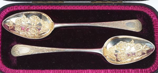 Two similarly decorated silver dessert serving spoons (2)