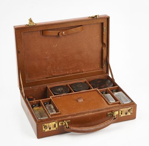 A silver and tortoiseshell mounted glass travelling toilet set