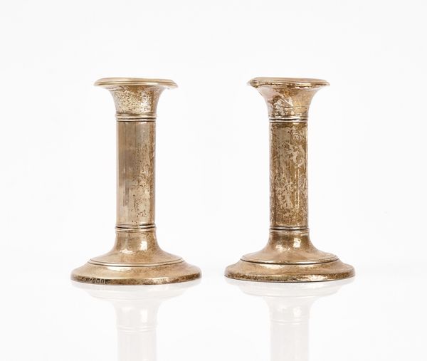 A pair of silver mounted candlesticks and a silver and tortoiseshell mounted glass smelling salts bottle (3)