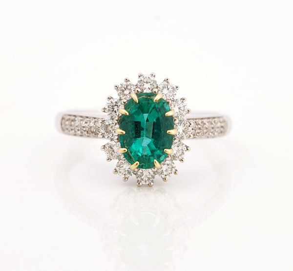 A white gold, emerald and diamond set oval cluster ring