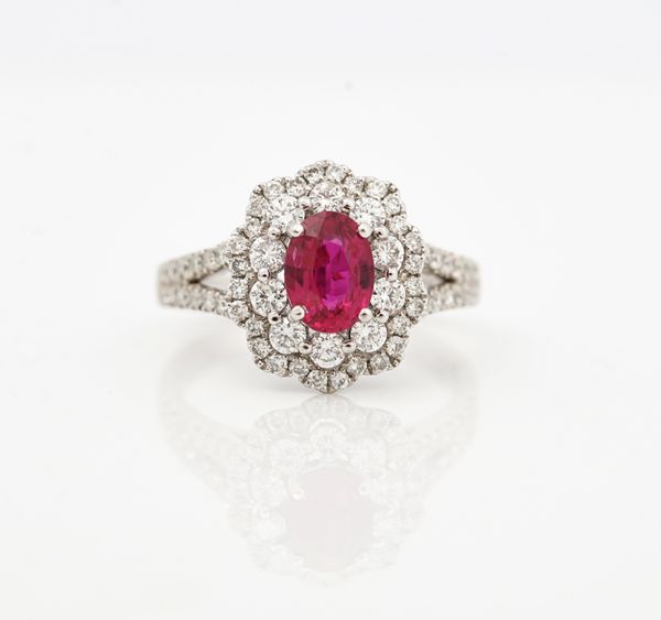 A platinum, ruby and diamond set shaped oval cluster ring
