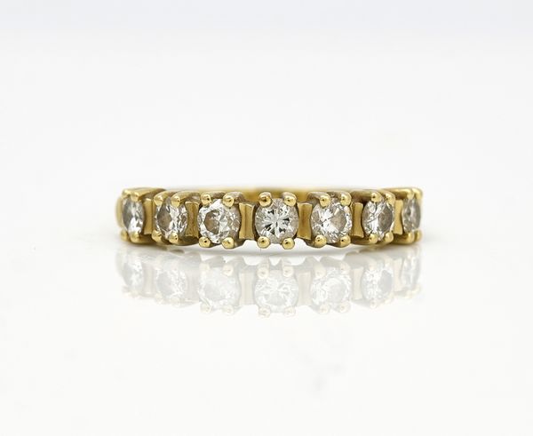 An 18ct gold and diamond set seven stone half hoop eternity ring
