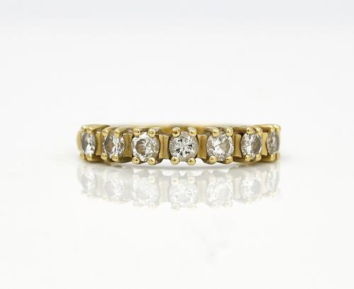 An 18ct gold and diamond set seven stone half hoop eternity ring