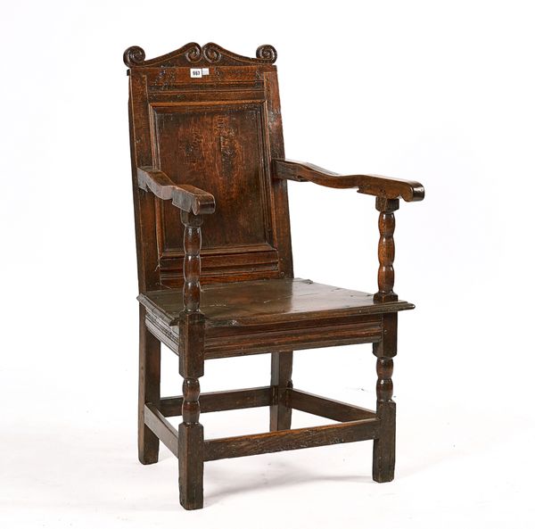 A CHARLES II JOINED OAK PANEL-BACK OPEN ARMCHAIR