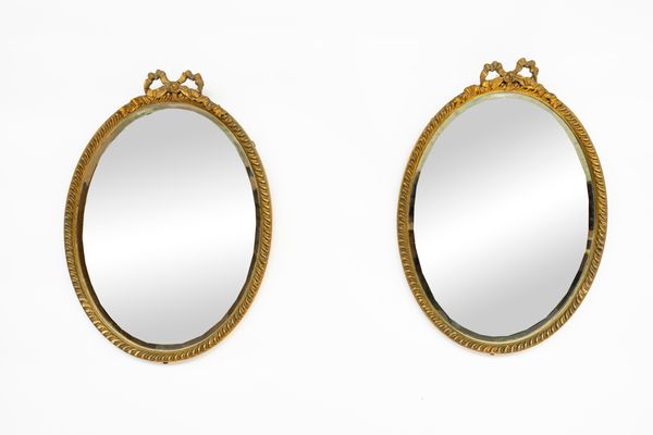 A PAIR OF EARLY 20TH CENTURY RIBBON-TIED GILT FRAMED OVAL WALL MIRRORS (2)