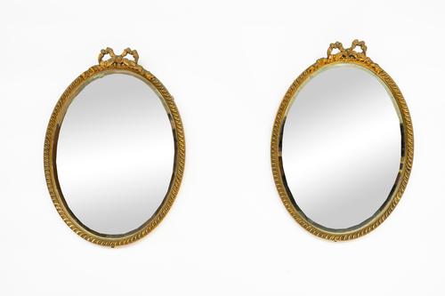 A PAIR OF EARLY 20TH CENTURY RIBBON-TIED GILT FRAMED OVAL WALL MIRRORS (2)