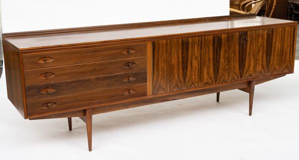 PROBABLY ROBERT HERITAGE FOR ARCHIE SHINE; A MID-20TH CENTURY DESIGN ROSEWOOD SIDEBOARD WITH AN ARRANGEMENT OF FOUR REEDED DRAWERS AND CUPBOARDS