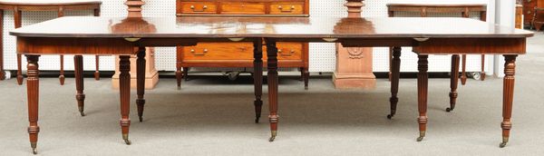 A REGENCY MAHOGANY EXTENDING DINING TABLE ON REEDED SUPPORTS TO INCLUDE FOUR EXTRA LEAVES