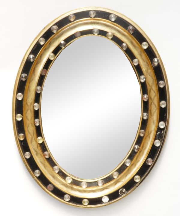 A 19TH CENTURY IRISH PARCEL GILT EBONISED AND HOBNAIL GLASS MOUNTED OVAL MIRROR