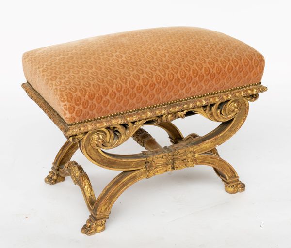 A 19TH CENTURY GILT FRAMED RECTANGULAR STOOL ON CARVED X-FRAME BASE