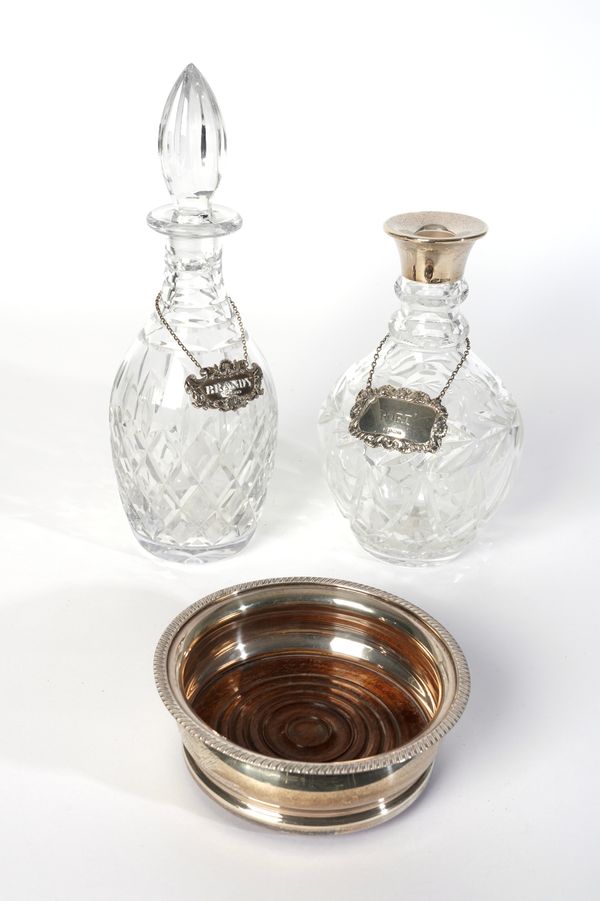 A SILVER MOUNTED BOTTLE COASTER AND TWO DECANTERS (5)