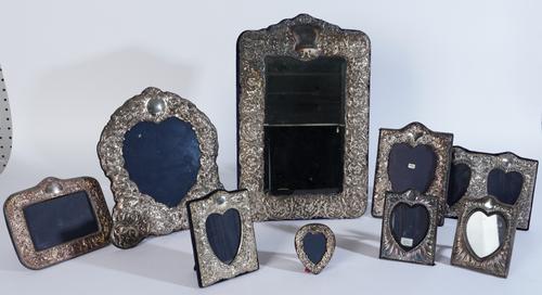 A SILVER MOUNTED MIRROR AND EIGHT PHOTOGRAPH FRAMES (9)