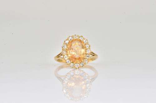 A GOLD, TOPAZ AND DIAMOND OVAL CLUSTER RING