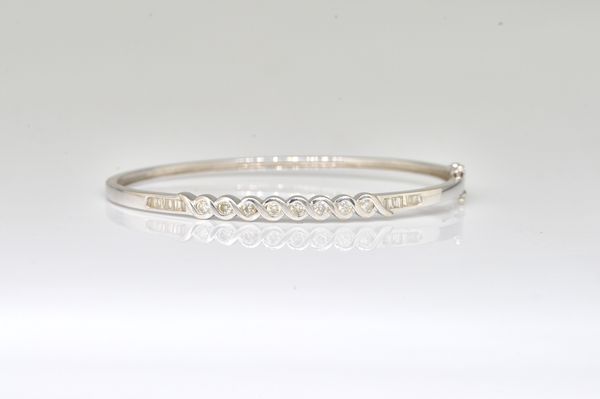 AN 18CT WHITE GOLD AND DIAMOND SET OVAL HINGED BANGLE