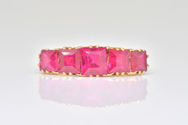 A GOLD AND SYNTHETIC RED GEM SET FIVE STONE RING